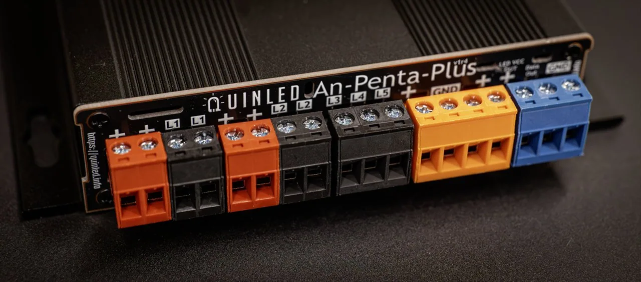 QuinLED An-Penta-Plus output side close-up, a row of orange, black, yellow and blue screw terminals labelled L1-L5 on the finned aluminium case