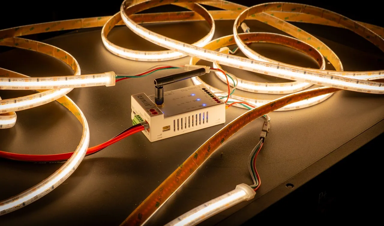 QuinLED Dig-COB-RGBW-896-160 strip in warm white looped around a QuinLED digital controller with WiFi antenna and pigtail connectors