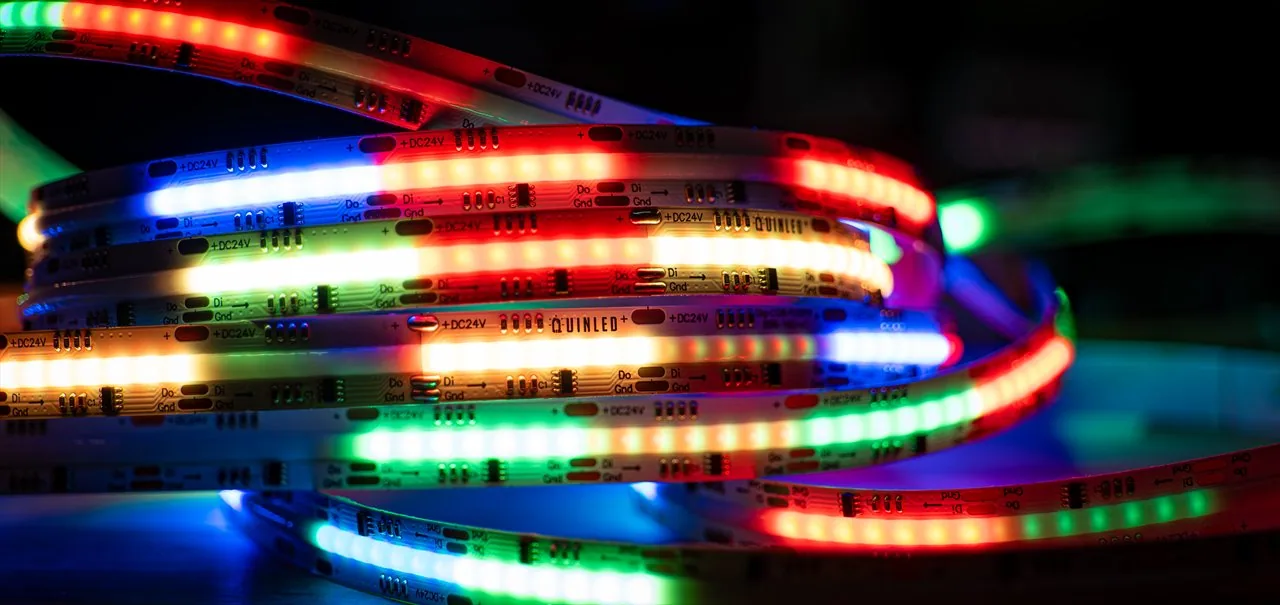 QuinLED Dig-COB-RGBW-896-160 strip coiled tight, macro of multicolour red/green/blue/white segments with QUINLED and DC24V data-pad labels